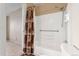 Bathroom with a shower-tub combination featuring a white tile surround at 4555 S Lowell Blvd, Denver, CO 80236