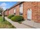 Brick townhome featuring manicured landscaping, private entrance, and well-maintained exterior at 4555 S Lowell Blvd, Denver, CO 80236
