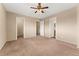 Main bedroom features neutral carpet and paint, ceiling fan, and multiple doorways at 4555 S Lowell Blvd, Denver, CO 80236