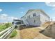 The backyard features a stone facade and stairs leading up to the deck with a white fence surrounding the yard at 1957 S Coolidge Way, Aurora, CO 80018