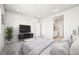 Spacious bedroom features a television, a sitting area, a plant, and an ensuite bathroom at 1957 S Coolidge Way, Aurora, CO 80018