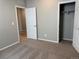 Neutral colored bedroom featuring a closet with sliding doors, carpet and door to another room at 1957 S Coolidge Way, Aurora, CO 80018