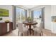 Bright dining area featuring a wood table with chairs, two windows, and sliding doors at 1957 S Coolidge Way, Aurora, CO 80018
