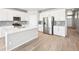 Modern kitchen with stainless steel appliances, large center island, and hardwood floors at 1957 S Coolidge Way, Aurora, CO 80018