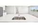 Kitchen island featuring stainless steel sink and appliances plus a view of living room at 1957 S Coolidge Way, Aurora, CO 80018