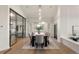 Dining room with glass door to living area, modern chandelier, and view of the backyard at 93 Glenmoor Dr, Cherry Hills Village, CO 80113