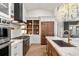 Gourmet kitchen featuring modern stainless-steel appliances, hardwood floors, stylish chandelier, and marble countertop at 93 Glenmoor Dr, Cherry Hills Village, CO 80113