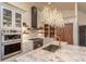 Elegant kitchen featuring marble countertops, custom cabinets, and a designer chandelier at 93 Glenmoor Dr, Cherry Hills Village, CO 80113