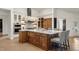 Kitchen island featuring barstool seating, a marble countertop, stunning chandelier, and modern stainless-steel appliances at 93 Glenmoor Dr, Cherry Hills Village, CO 80113