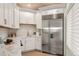 Modern kitchen featuring stainless steel refrigerator, marble countertops, and custom white cabinetry with gold hardware at 93 Glenmoor Dr, Cherry Hills Village, CO 80113