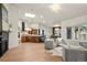 Open living space featuring hardwood floors, fireplace, chandeliers, modern furniture, and views of the gourmet kitchen at 93 Glenmoor Dr, Cherry Hills Village, CO 80113