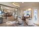 Sitting area adjacent to a kitchen and divided by glass doors features unique window and chandelier details at 93 Glenmoor Dr, Cherry Hills Village, CO 80113