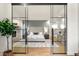 Modern main bedroom suite with glass partition, a stone fireplace, hardwood flooring, and a plush king bed at 93 Glenmoor Dr, Cherry Hills Village, CO 80113