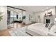Bright bedroom with a stone fireplace, a plush king bed, hardwood floors, and access to an adjacent study area at 93 Glenmoor Dr, Cherry Hills Village, CO 80113