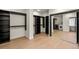 Spacious walk-in closet featuring black shelving, hardwood floors, mirrored doors, and in-unit laundry at 93 Glenmoor Dr, Cherry Hills Village, CO 80113