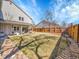 Expansive backyard with a covered patio area, grass lawn, and wood fencing at 3706 E Easter Dr, Centennial, CO 80122