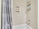 Bright bathroom featuring a bathtub with tiled walls, showerhead and a blue patterned shower curtain at 3706 E Easter Dr, Centennial, CO 80122