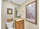 Charming powder room with a wooden vanity, granite countertop, decorative art, and neutral color palette at 3706 E Easter Dr, Centennial, CO 80122