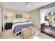 Cozy bedroom with a plush bed, woven ottomans, and inviting natural light from the window at 3706 E Easter Dr, Centennial, CO 80122