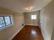 Cozy bedroom has hardwood floors, shelving, natural light, and a door to another room at 1129 2Nd Ave, Longmont, CO 80501