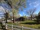 Charming home with large mature trees, fenced yard, and lush green grass at 1129 2Nd Ave, Longmont, CO 80501