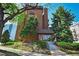 Brick building exterior featuring mature trees, tidy landscaping, and an inviting entry with concrete steps at 4110 Hale Pkwy # 5F, Denver, CO 80220
