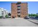 Brick apartment building with a large parking lot and multiple cars parked in front at 4110 Hale Pkwy # 5F, Denver, CO 80220