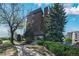 Brick building exterior showcasing lush trees, trimmed shrubbery and a welcoming entrance with concrete walkway at 4110 Hale Pkwy # 5F, Denver, CO 80220