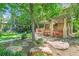 Lush backyard with a covered patio, lush greenery, and a stone walkway creates a serene and inviting outdoor space at 1827 N Bellaire St, Denver, CO 80220