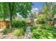 Beautiful backyard with a stone pathway leading to a charming shed and lush greenery at 1827 N Bellaire St, Denver, CO 80220