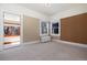 Bedroom with warm beige walls and carpeted floors featuring an open door to another room, and bright light from windows at 1827 N Bellaire St, Denver, CO 80220