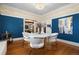 Elegant dining room featuring hardwood floors, contemporary light fixture and vibrant wall color at 1827 N Bellaire St, Denver, CO 80220