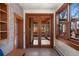 Hallway with hardwood trim, a window, and glass pane doors that open up to a porch creating seamless indoor-outdoor living at 1827 N Bellaire St, Denver, CO 80220