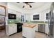 Bright kitchen featuring white cabinetry, stainless steel appliances, and functional island for cooking at 1827 N Bellaire St, Denver, CO 80220