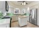 Bright kitchen with island, stainless steel appliances, and green tile backsplash at 1827 N Bellaire St, Denver, CO 80220