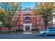 A striking brick building with trees lining the street, complemented by classic architectural details at 836 E 17Th Ave # 2E, Denver, CO 80218