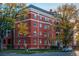 Brick building with white trim, manicured lawn, and street parking at 836 E 17Th Ave # 2E, Denver, CO 80218