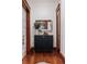 Bright hallway showcasing sleek cabinet, reflective mirror, and rich hardwood flooring at 836 E 17Th Ave # 2E, Denver, CO 80218