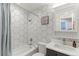 Modern bathroom featuring hexagon tiles, a sleek vanity, and a shower-tub combo at 7966 Ingalls St, Arvada, CO 80003