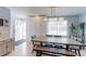 Bright dining area with a large wooden table, a light fixture, and storage cabinets at 7966 Ingalls St, Arvada, CO 80003