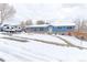 Inviting blue single-story home with a landscaped yard partly covered in snow, plus a recreational vehicle on the driveway at 7966 Ingalls St, Arvada, CO 80003