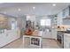 Modern kitchen featuring stainless steel appliances, white cabinets, a tiled backsplash, and a kitchen island at 7966 Ingalls St, Arvada, CO 80003