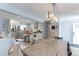 Open-concept kitchen and dining area with stainless steel appliances, white cabinets, and a wooden dining table at 7966 Ingalls St, Arvada, CO 80003