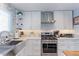 Bright kitchen featuring white cabinets, stainless steel appliances, and a modern backsplash at 7966 Ingalls St, Arvada, CO 80003