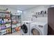 The laundry room has generous shelving and a full washer and dryer set at 7966 Ingalls St, Arvada, CO 80003