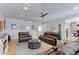 Bright living room featuring hardwood floors, a modern ceiling fan, a large sofa set, and access to the dining area at 7966 Ingalls St, Arvada, CO 80003