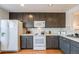 Modern kitchen with dark cabinets and white appliances at 410 Smith Cir, Erie, CO 80516