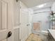 Well-lit bathroom with a glass-enclosed shower, dual closets, and tile flooring at 5745 W Atlantic Pl # 104, Lakewood, CO 80227
