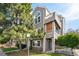 Exterior view of a well-maintained townhome with arched windows, a balcony, and lush landscaping at 5745 W Atlantic Pl # 104, Lakewood, CO 80227