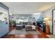 Open-concept living room with kitchen pass-through, gray sectional, and hardwood floors at 5745 W Atlantic Pl # 104, Lakewood, CO 80227
